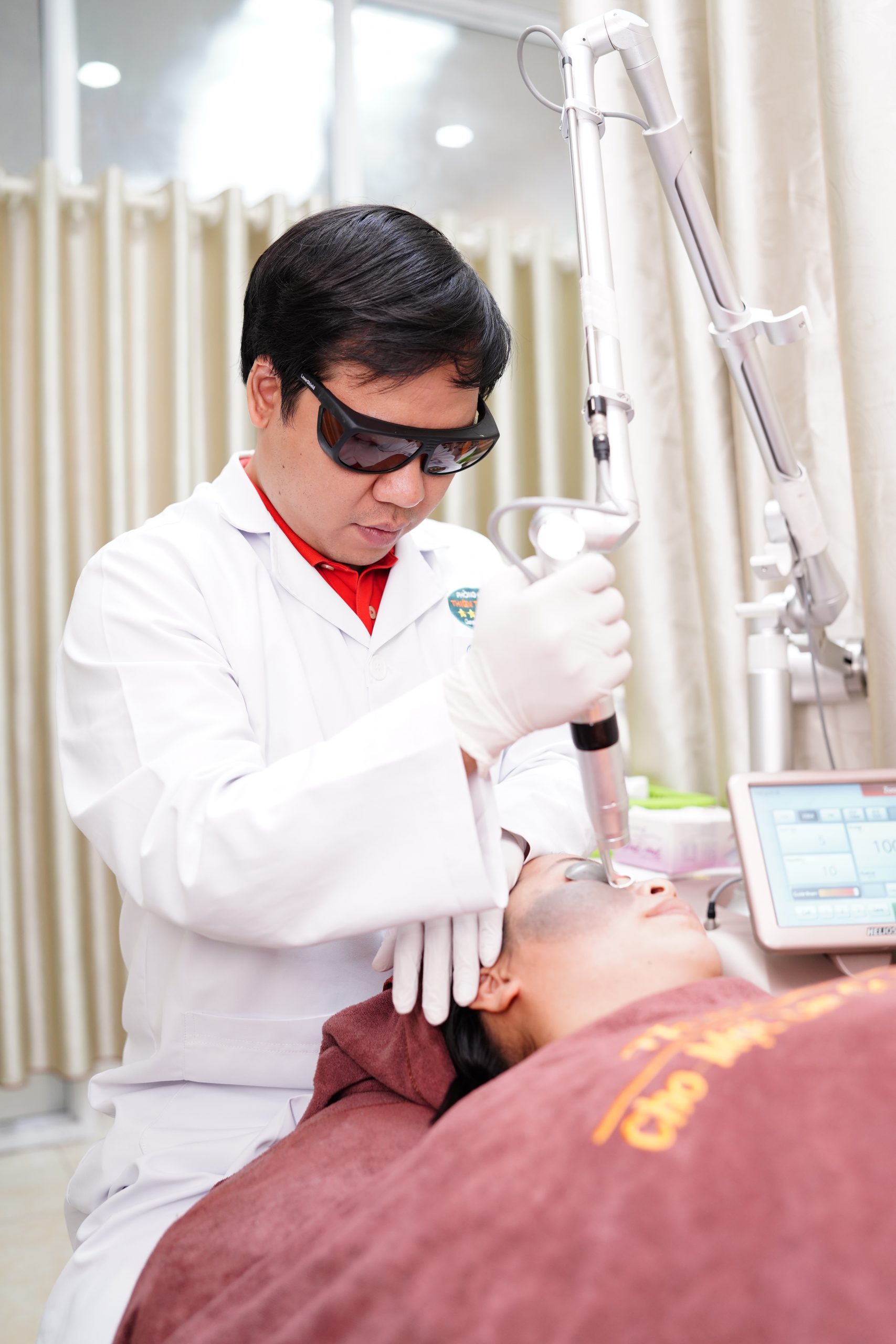Hình ảnh: Thạc sĩ - Bác sĩ Chuyên Khoa II Nguyễn Tiến Thành đang hỗ trợ điều trị bớt sắc tố cho bệnh nhân.